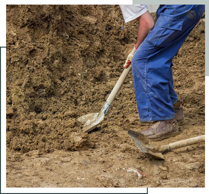 A person digging in the dirt with an shovel.