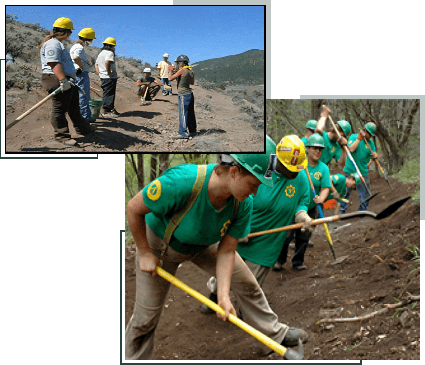A group of men in green shirts and hard hats working on a hill.